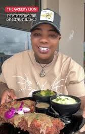 A guest enjoying a soul food platter at The Greedy Lion